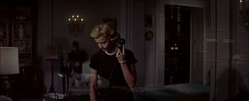 Movie still from “BUtterfield 8” (1960), directed by Daniel Mann – A woman talking on a phone while wearing pearls; Medium shot, Low angle