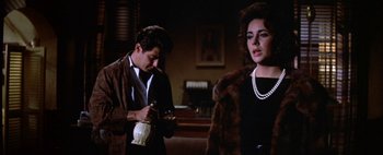 Movie still from “BUtterfield 8” (1960), directed by Daniel Mann – A man and a woman standing next to each other in a room; Medium shot, Over the shoulder angle