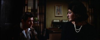 Movie still from “BUtterfield 8” (1960), directed by Daniel Mann – A man and a woman sitting in front of each other in a room; Medium shot, Over the shoulder angle
