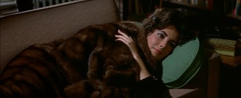 Movie still from “BUtterfield 8” (1960), directed by Daniel Mann – A woman in a fur coat is posing for a picture; Close Up shot, High angle