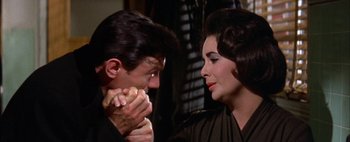 Movie still from “BUtterfield 8” (1960), directed by Daniel Mann – A man and a woman are eating a hot dog together; Close Up shot, High angle