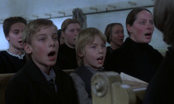 Movie still from “Babette's Feast” (1987), directed by Gabriel Axel – A group of young people singing together in a room; Close Up shot, High angle