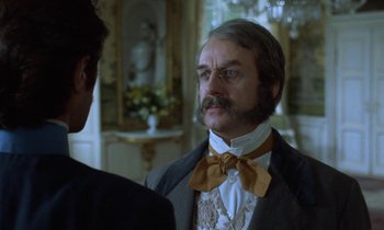 Movie still from “Babette's Feast” (1987), directed by Gabriel Axel – A man in a suit and bow tie talking to another man in a suit and bow tie; Close Up shot, Over the shoulder angle