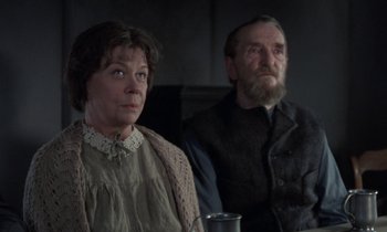 Movie still from “Babette's Feast” (1987), directed by Gabriel Axel – A man and a woman sitting next to each other; Medium shot, Low angle