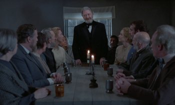 Movie still from “Babette's Feast” (1987), directed by Gabriel Axel – A group of people sitting around a dinner table; Wide shot, Over the shoulder angle