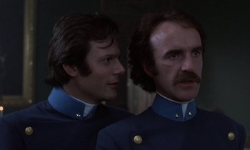 Movie still from “Babette's Feast” (1987), directed by Gabriel Axel – Two men in blue uniforms are looking at each other; Close Up shot, Low angle