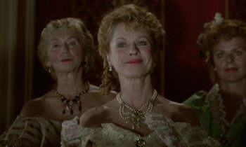 Movie still from “Babette's Feast” (1987), directed by Gabriel Axel – A woman in a white dress with a green necklace; Close Up shot, Low angle
