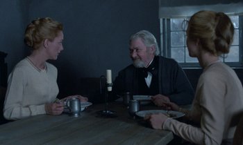 Movie still from “Babette's Feast” (1987), directed by Gabriel Axel – A group of people sitting at a table with plates of food; Medium shot, Over the shoulder angle