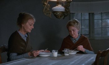 Movie still from “Babette's Feast” (1987), directed by Gabriel Axel – A couple of women sitting at a dinner table; Medium shot, High angle
