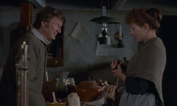 Movie still from “Babette's Feast” (1987), directed by Gabriel Axel – A man and a woman are talking in a kitchen; Medium shot, Over the shoulder angle