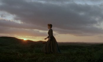 Movie still from “Babette's Feast” (1987), directed by Gabriel Axel – A woman in a long dress walking across a field; Extreme Wide shot, Low angle