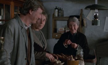 Movie still from “Babette's Feast” (1987), directed by Gabriel Axel – A group of people sitting at a table with food; Medium shot, Over the shoulder angle