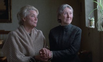 Movie still from “Babette's Feast” (1987), directed by Gabriel Axel – Two older women holding hands in a room; Close Up shot, Low angle