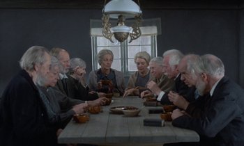 Movie still from “Babette's Feast” (1987), directed by Gabriel Axel – A group of people sitting around a table eating food; Wide shot, High angle