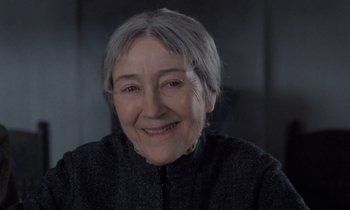 Movie still from “Babette's Feast” (1987), directed by Gabriel Axel – An older woman smiling for the camera; Close Up shot, Over the shoulder angle