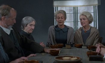 Movie still from “Babette's Feast” (1987), directed by Gabriel Axel – A group of people sitting at a table with bowls of food; Medium shot, High angle