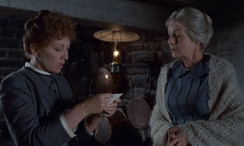 Movie still from “Babette's Feast” (1987), directed by Gabriel Axel – Two older women standing next to each other in a room; Medium shot, Over the shoulder angle
