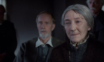 Movie still from “Babette's Feast” (1987), directed by Gabriel Axel – An older man and a younger woman standing next to each other; Close Up shot, Low angle