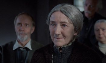 An older woman with a gray hair and a gray beard