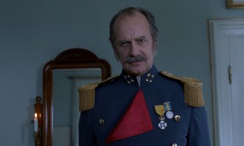Movie still from “Babette's Feast” (1987), directed by Gabriel Axel – An older man in a military uniform with a medal around his neck; Close Up shot, Low angle