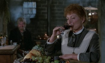 Movie still from “Babette's Feast” (1987), directed by Gabriel Axel – An older woman drinking a glass of red wine; Medium shot, Over the shoulder angle