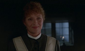 Movie still from “Babette's Feast” (1987), directed by Gabriel Axel – A person wearing a suit and tie; Close Up shot, Over the shoulder angle