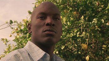 Movie still from “Baby Boy” (2001), directed by John Singleton – A person with a tree in the background; Close Up shot, Low angle