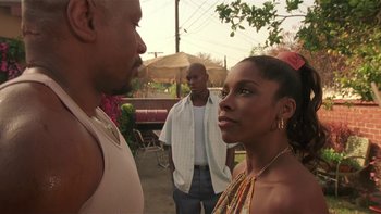 Movie still from “Baby Boy” (2001), directed by John Singleton – A man and a woman standing next to each other in front of another man; Close Up shot, Over the shoulder angle