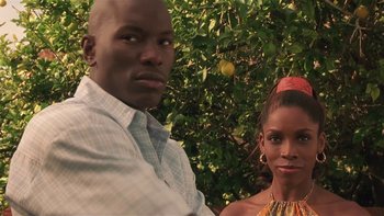 Movie still from “Baby Boy” (2001), directed by John Singleton – A man and a woman standing next to each other in front of a tree; Close Up shot, Low angle