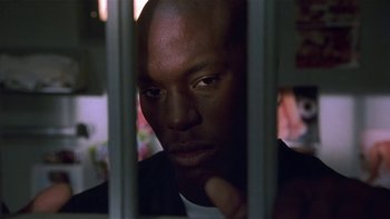 Movie still from “Baby Boy” (2001), directed by John Singleton – A person behind a fence; Close Up shot, Low angle