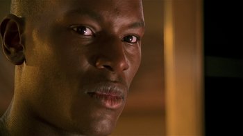 Movie still from “Baby Boy” (2001), directed by John Singleton – A man's face in a dark room; Close Up shot, Over the shoulder angle