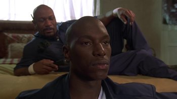 Movie still from “Baby Boy” (2001), directed by John Singleton – A man sitting on the ground with another man sitting on the floor; Close Up shot, Low angle