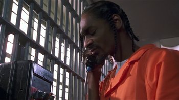 Movie still from “Baby Boy” (2001), directed by John Singleton – A man in an orange prison uniform talking on a cell phone; Close Up shot, Low angle