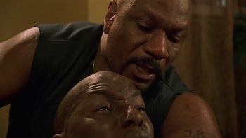 Movie still from “Baby Boy” (2001), directed by John Singleton – An older black man is holding a younger black man; Close Up shot, Low angle