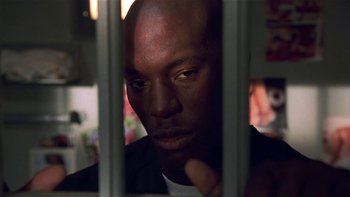 Movie still from “Baby Boy” (2001), directed by John Singleton – A person behind a fence; Close Up shot, Low angle