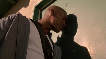 Movie still from “Baby Boy” (2001), directed by John Singleton – A bald man with a black tie and a white dress shirt; Close Up shot, Low angle