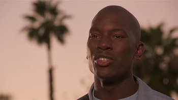 Movie still from “Baby Boy” (2001), directed by John Singleton – A person with a palm tree in the background; Close Up shot, Low angle