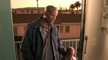 Movie still from “Baby Boy” (2001), directed by John Singleton – A man and a child standing next to each other on a balcony; Medium shot, Low angle