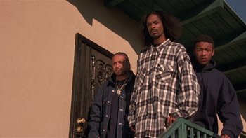 Movie still from “Baby Boy” (2001), directed by John Singleton – A couple of men standing next to each other on a porch; Medium shot, Low angle