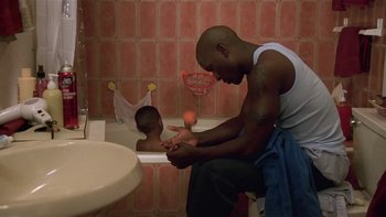 Movie still from “Baby Boy” (2001), directed by John Singleton – A man and a baby in a bathroom; Medium shot, High angle