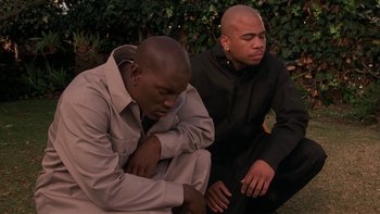 Movie still from “Baby Boy” (2001), directed by John Singleton – A couple of men sitting next to each other on the ground; Medium shot, High angle