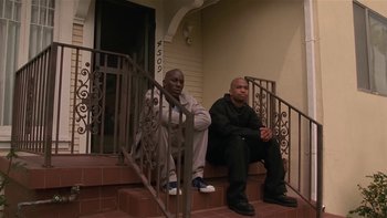 Movie still from “Baby Boy” (2001), directed by John Singleton – A couple of men sitting on top of a set of stairs; Wide shot, Low angle