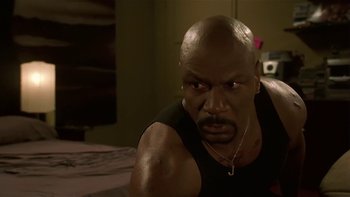 Movie still from “Baby Boy” (2001), directed by John Singleton – A bald man with a black tank top is looking at the camera; Close Up shot, Low angle