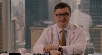 Movie still from “Baby Mama” (2008), directed by Michael McCullers – A man wearing a lab coat sitting at a table; Close Up shot, Over the shoulder angle
