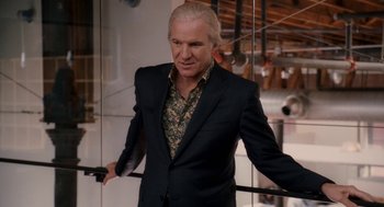 Movie still from “Baby Mama” (2008), directed by Michael McCullers – A man in a black suit standing next to a glass wall; Medium shot, Over the shoulder angle