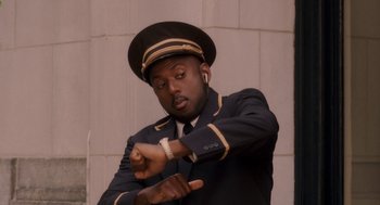 Movie still from “Baby Mama” (2008), directed by Michael McCullers – A man wearing a uniform and a hat is looking at his watch; Medium shot, Low angle