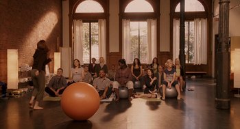 Movie still from “Baby Mama” (2008), directed by Michael McCullers – A group of people sitting in front of an orange ball; Wide shot, High angle