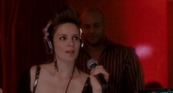Movie still from “Baby Mama” (2008), directed by Michael McCullers – A woman wearing headphones and holding a microphone in front of a man; Close Up shot, Over the shoulder angle