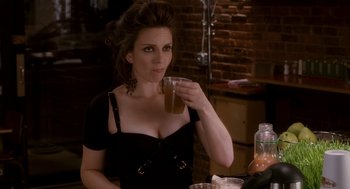 Movie still from “Baby Mama” (2008), directed by Michael McCullers – A woman sitting at a table with a drink in her hand; Medium shot, Over the shoulder angle