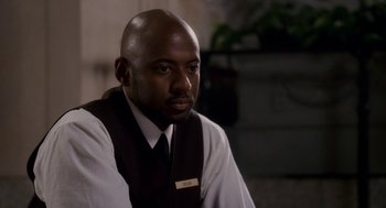 Movie still from “Baby Mama” (2008), directed by Michael McCullers – A man sitting down wearing a vest and tie; Close Up shot, Over the shoulder angle